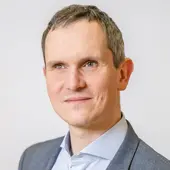 Steffen Erzgraber, Landesgeschäftsführer Verbands- und Sozialpolitik, im grauen Anzug vor hellgrauem Hintergrund